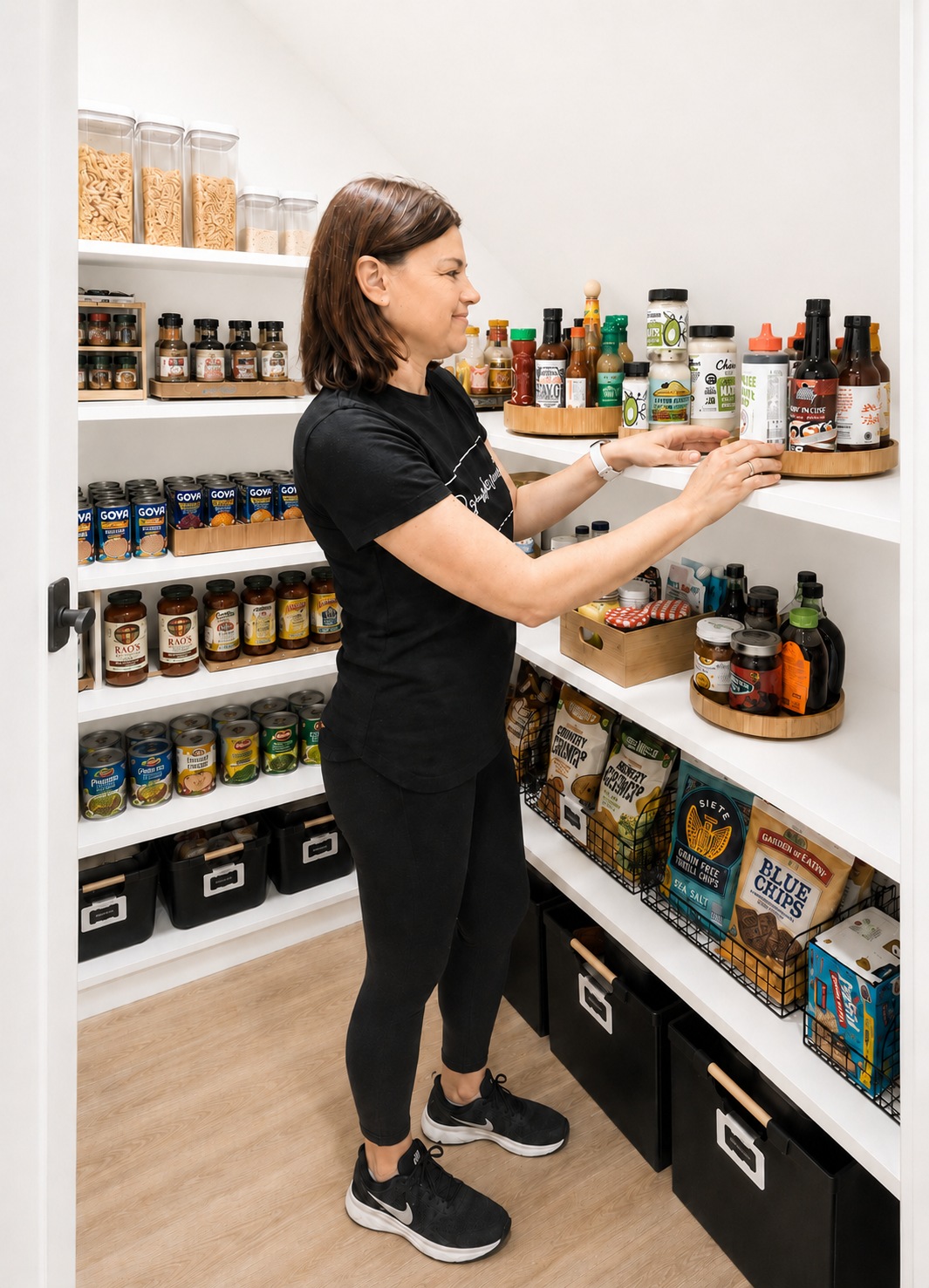 Tammy of Organize4Sanity in her logo tee, setting up a pantry shelf